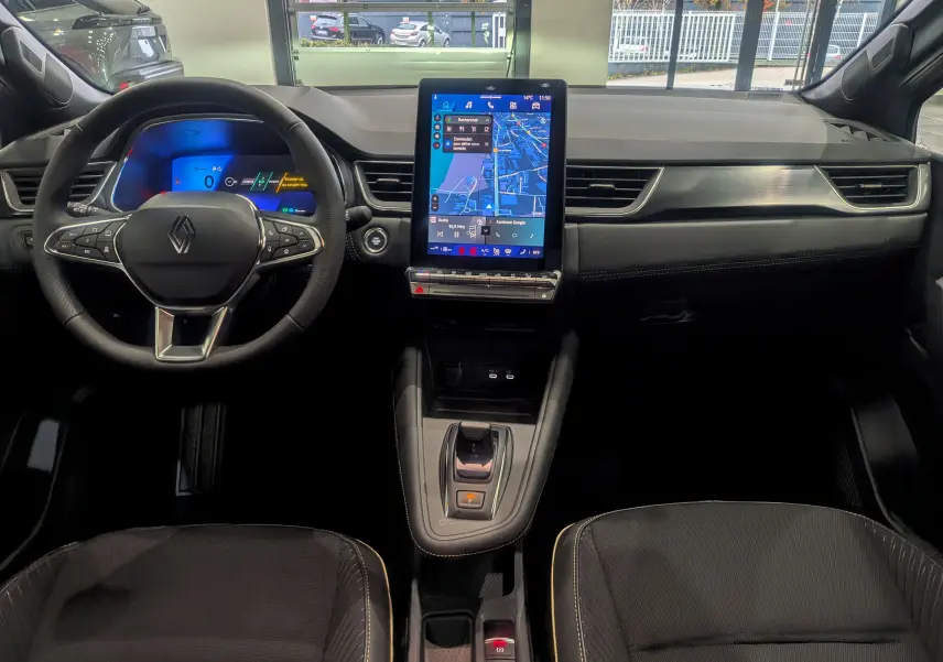 Vue intérieure avant du Renault SYMBIOZ gris Cassiopé, avec tableau de bord numérique et écran tactile central vertical.