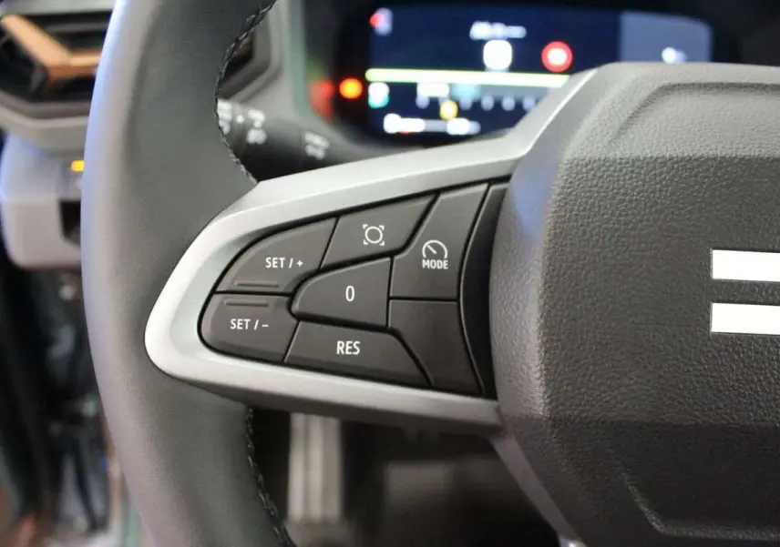 Gros plan sur le volant cuir noir de la Dacia Bigster 2026, montrant les commandes de régulateur de vitesse à gauche.