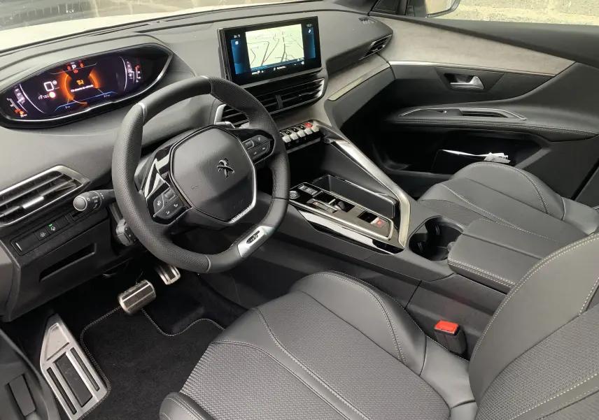 Intérieur du Peugeot 5008 GT 2024, vue côté conducteur, avec tableau de bord numérique et sellerie cuir gris.
