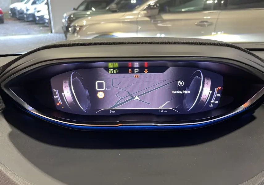 Affichage numérique du tableau de bord du Peugeot 5008 GT 2024, avec navigation et indicateurs lumineux visibles.