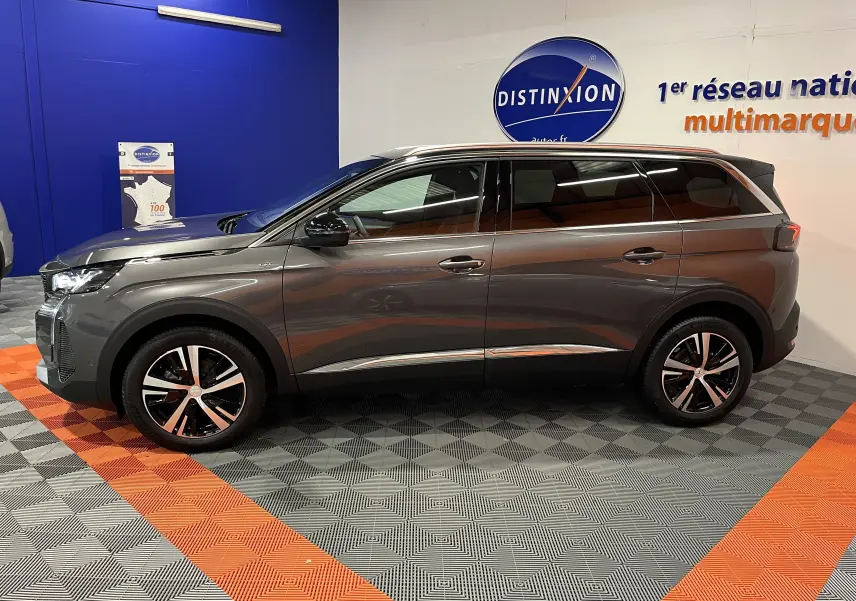 Peugeot 5008 BlueHDi 130 GT gris platinium vue de profil côté gauche, avec jantes alliage bicolores et vitres teintées.