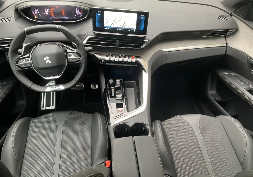 Vue intérieure avant du Peugeot 5008 GT 2024, tableau de bord moderne avec écran tactile et volant compact noir.