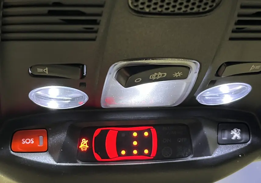 Gros plan sur les commandes gauche du volant du Peugeot 5008 gris platinium 2024, boutons LIST, SRC et téléphone.