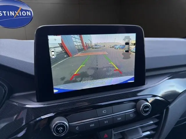 Écran central montrant la caméra de recul du Ford Kuga gris 2024, version hybride essence, avec interface de stationnement assisté.