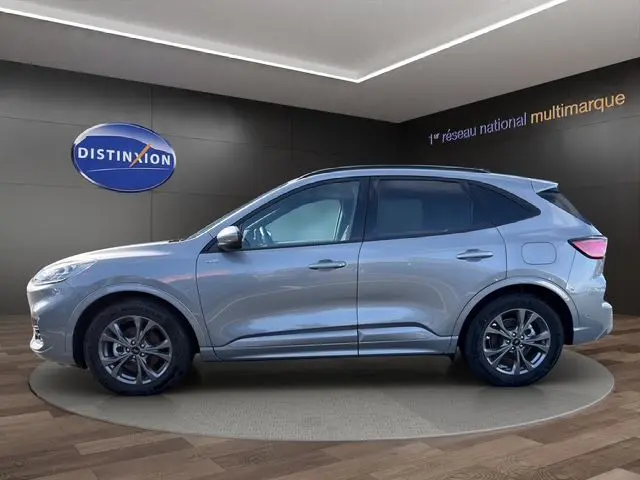 Vue de profil droit du Ford Kuga 2024 gris, version hybride ST-Line X avec jantes alliage distinctives.