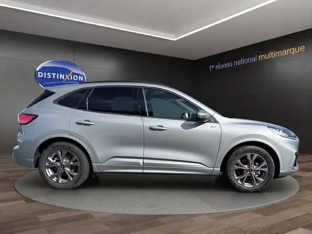 Vue latérale droite d'un Ford Kuga gris 2024 finition ST-Line X avec jantes alliage et vitres teintées.