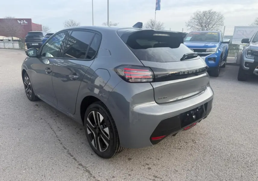 Vue 3/4 arrière droite d'une Peugeot 208 Hybrid 110 gris métallisé avec jantes alliage et feux arrière LED distinctifs.
