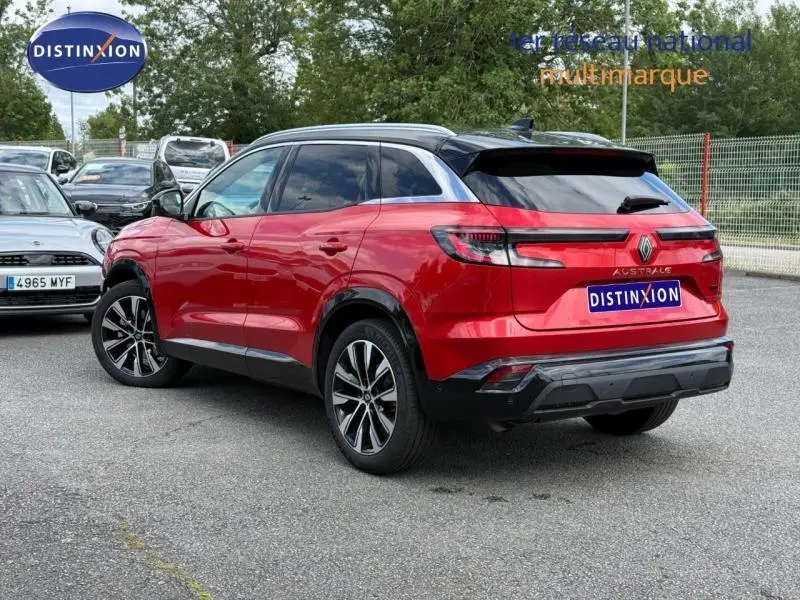 Vue 3/4 arrière droite d'un Renault Austral 2025 rouge Flamme avec toit noir et feux arrière LED distinctifs.