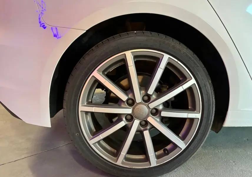 Gros plan sur la roue arrière droite d'une Audi A3 Sportback blanche de 2019, mettant en valeur la jante alliage à dix branches.