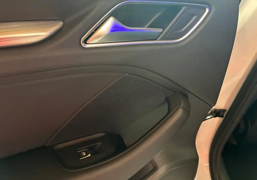 Détail de la porte intérieure côté gauche en cuir noir de l'Audi A3 Sportback blanc, avec poignée et bouton de verrouillage.