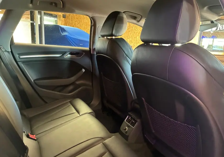 Vue intérieure arrière de l’Audi A3 Sportback 2019 avec sièges en cuir noir et aérateurs centraux entre les sièges avant.