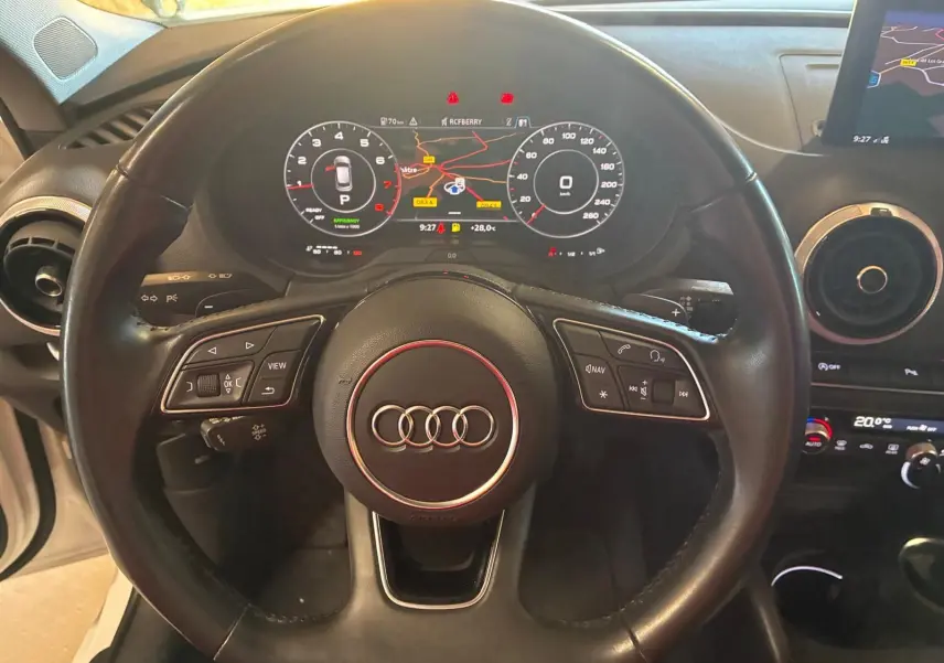 Vue rapprochée du volant noir de l'Audi A3 Sportback 2019 avec tableau de bord numérique et écran GPS visible.