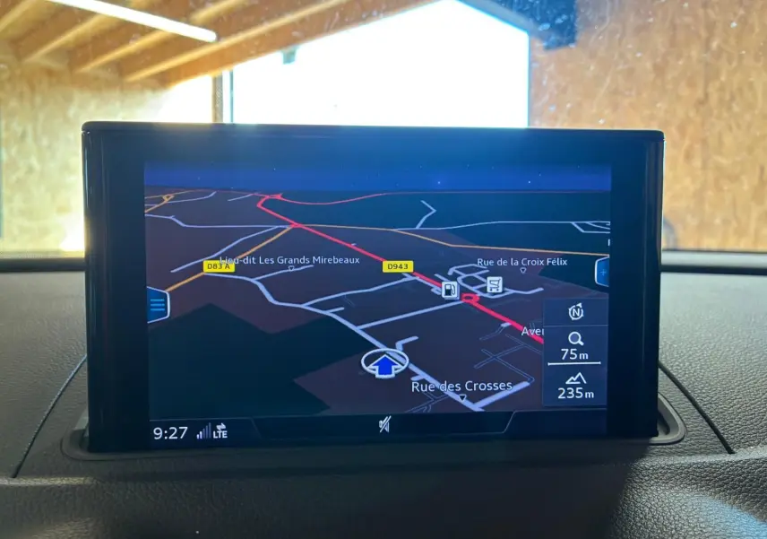 Écran GPS intégré affichant une carte de navigation, situé sur le tableau de bord d'une Audi A3 Sportback blanche.