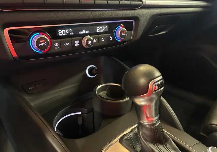Gros plan sur la console centrale intérieure de l'Audi A3 Sportback 2019, avec levier de vitesse S tronic et commandes de climatisation.