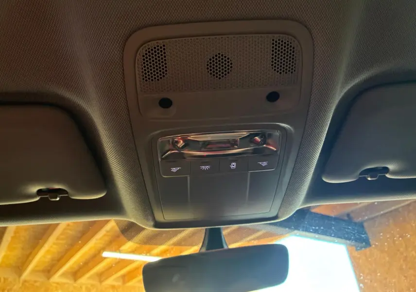 Vue intérieure du plafonnier avant de l'Audi A3 Sportback blanc, avec commandes d'éclairage et rétroviseur central visible.