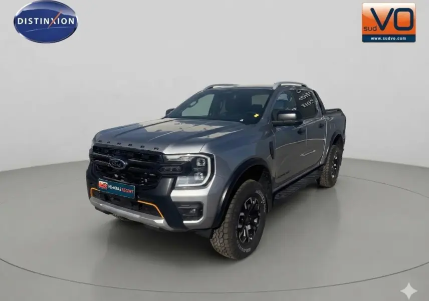 Vue 3/4 avant droite du Ford Ranger gris 2025 avec barres de toit et jantes alliage noires.