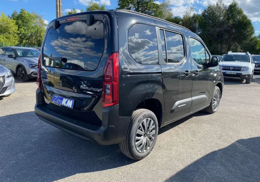 Vue 3/4 arrière droite d’un Citroën Berlingo noir métallisé avec vitres surteintées et hayon arrière vitré.