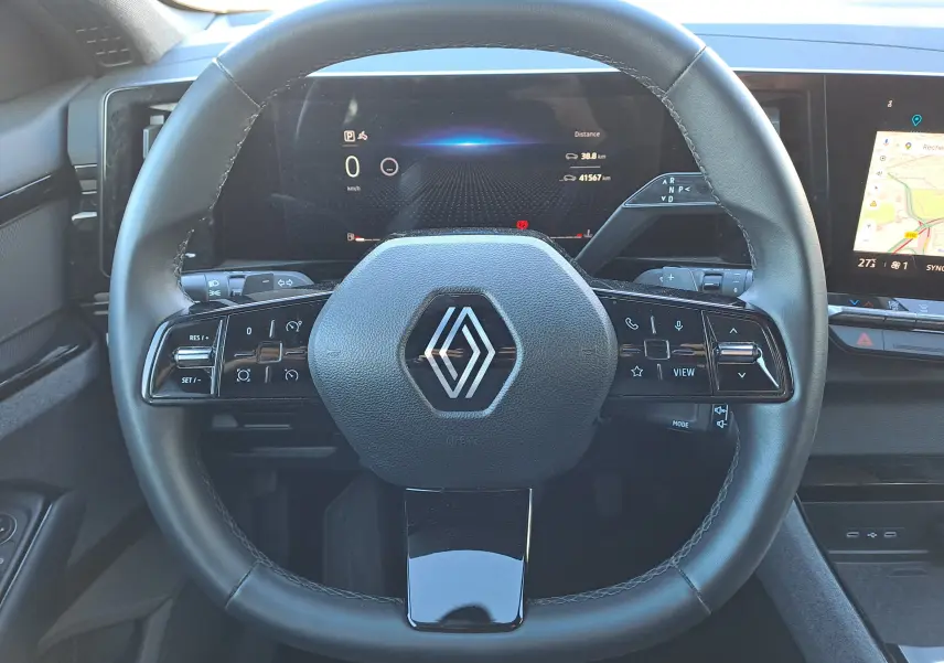 Vue rapprochée du volant noir de la Renault Austral 2023 avec tableau de bord numérique et écran tactile latéral.