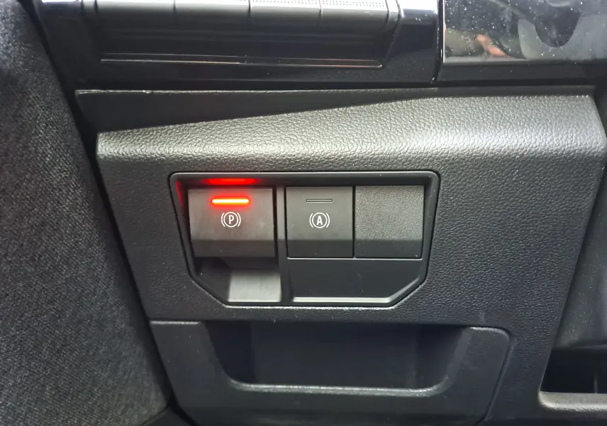 Gros plan sur les boutons du frein à main électrique et de l'arrêt automatique dans un Renault Austral gris schiste 2023.