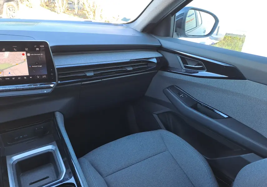 Vue intérieure côté passager du Renault Austral 2023 gris schiste, avec tableau de bord moderne et sièges tissu gris.