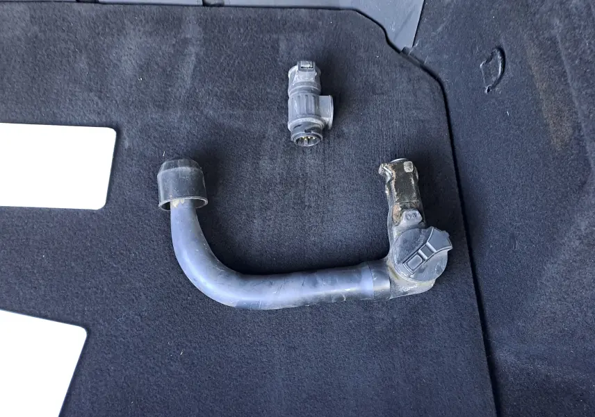 Gros plan sur attelage amovible posé sur le tapis noir du coffre d’un Renault Austral gris schiste 2023.