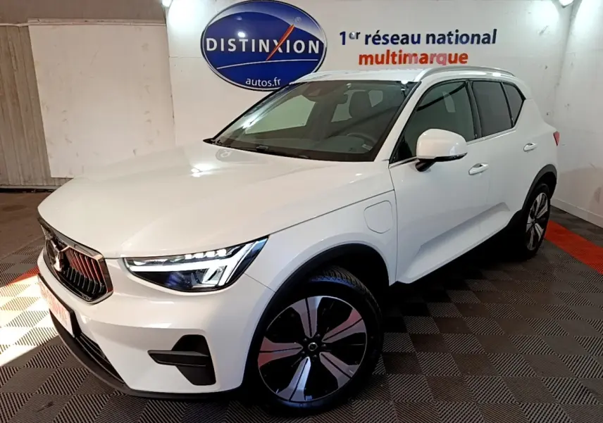 Vue 3/4 avant droit d'un Volvo XC40 hybride rechargeable blanc avec jantes noires et détails chromés.