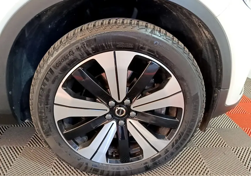 Gros plan sur la roue avant droite du Volvo XC40 Recharge T5 262 DCT7 Plus avec jante bicolore noir et argent