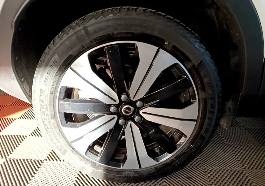 Gros plan sur la roue avant droite du Volvo XC40 Recharge T5 262 DCT7 Plus avec jante bicolore noire et argent.