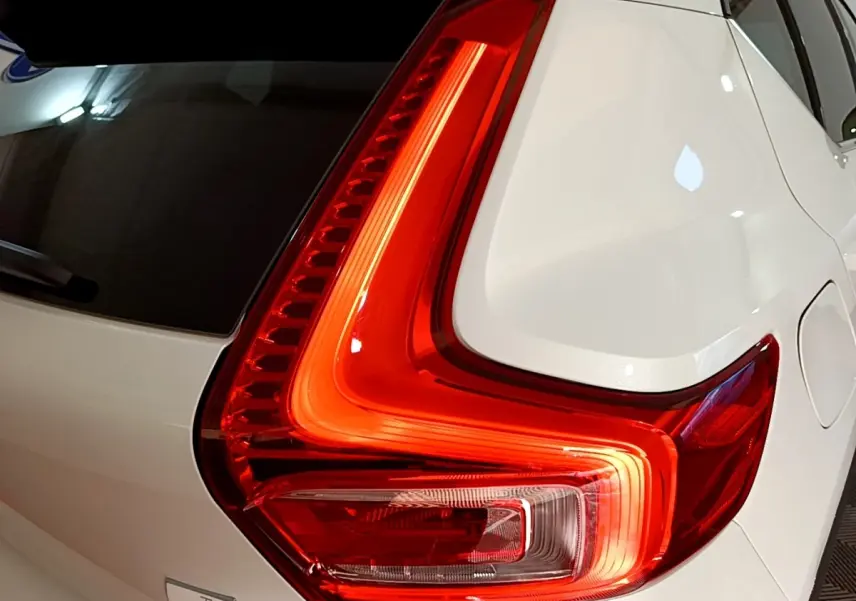Gros plan sur le feu arrière droit rouge vif du Volvo XC40 Recharge T5 262 DCT7 Plus blanc nacré.