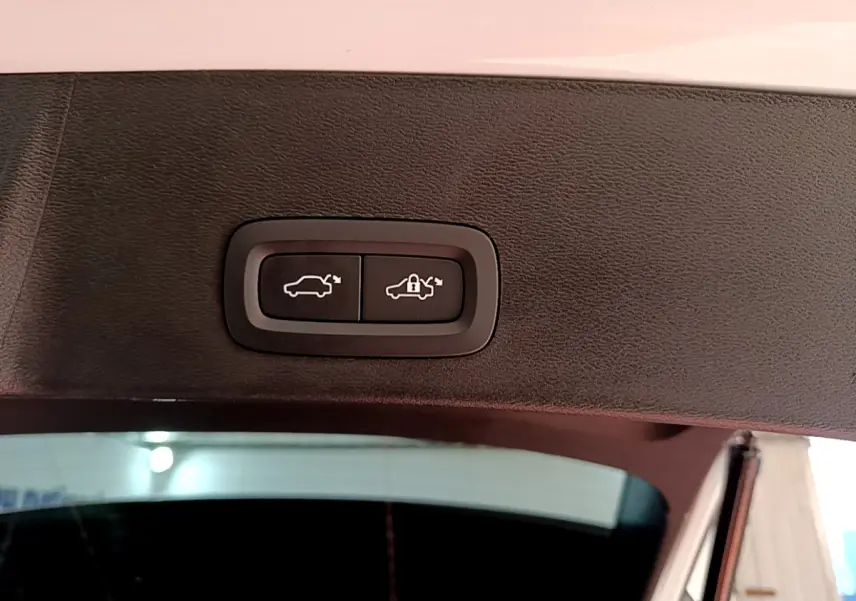 Gros plan sur les boutons de fermeture électrique du coffre du Volvo XC40 Recharge T5 262 DCT7 Plus, intérieur noir.