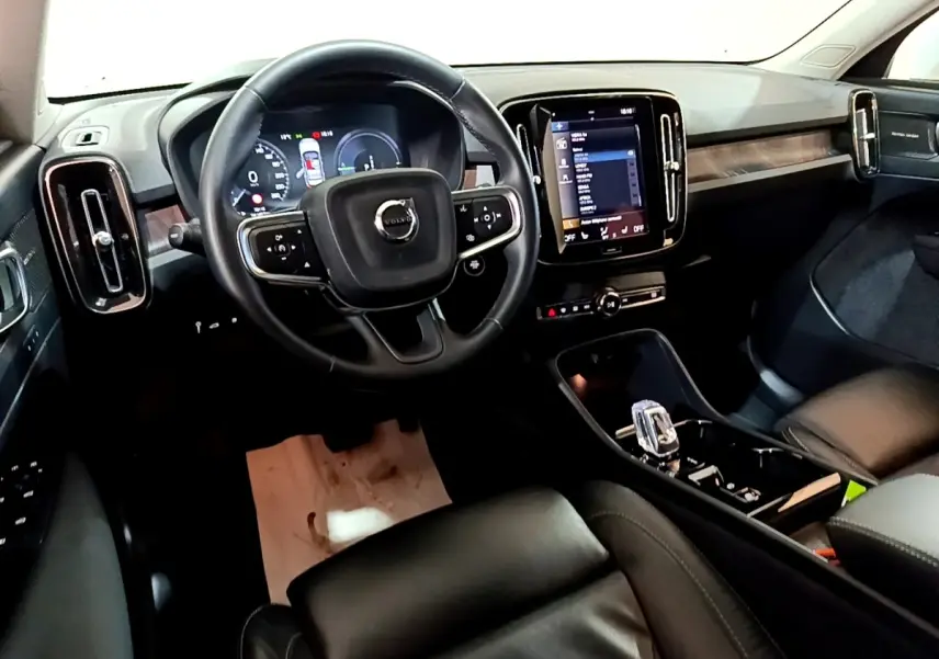 Intérieur noir du Volvo XC40 Recharge T5 2023, vue depuis le siège conducteur sur le tableau de bord et écran tactile central.