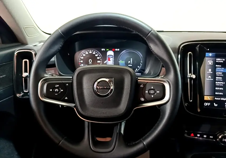 Vue centrée sur le volant noir du Volvo XC40 Recharge T5 2023 avec tableau de bord numérique et écran tactile latéral.