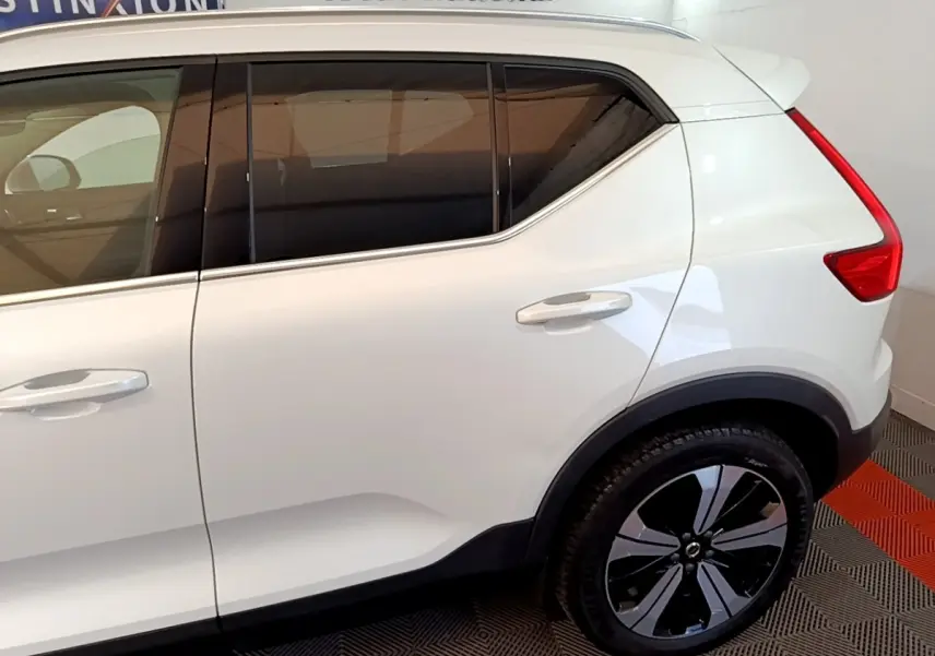 Vue latérale droite d’un Volvo XC40 Recharge T5 blanc avec jantes noires et vitres teintées.