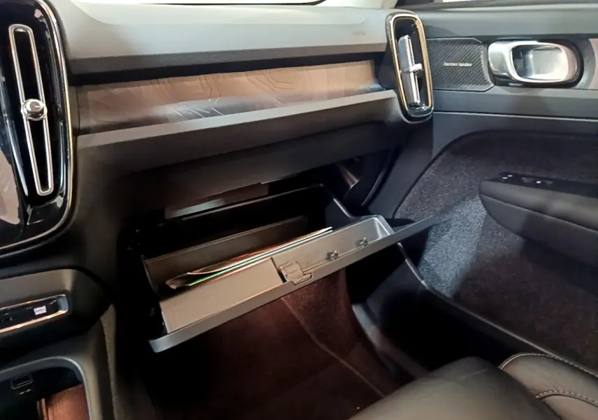 Vue intérieure côté passager du tableau de bord noir et boîte à gants ouverte du Volvo XC40 Recharge T5 2023.
