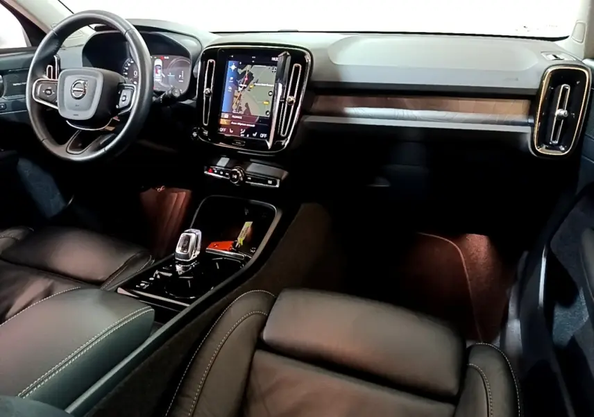 Intérieur noir du Volvo XC40 Recharge T5 2023 vu côté conducteur, avec écran tactile central et volant multifonctions.