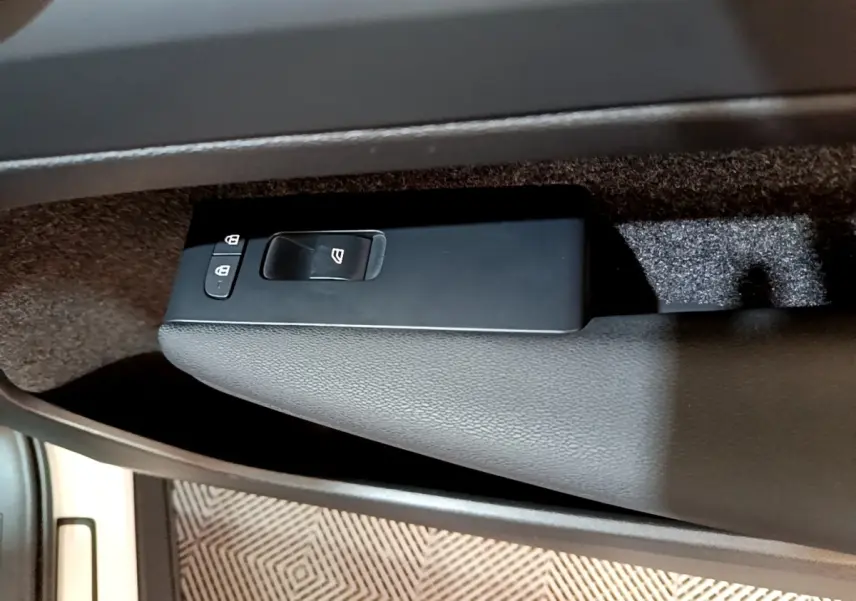 Gros plan sur la commande de lève-vitre et verrouillage sur la porte intérieure côté conducteur du Volvo XC40 hybride rechargeable 2023.