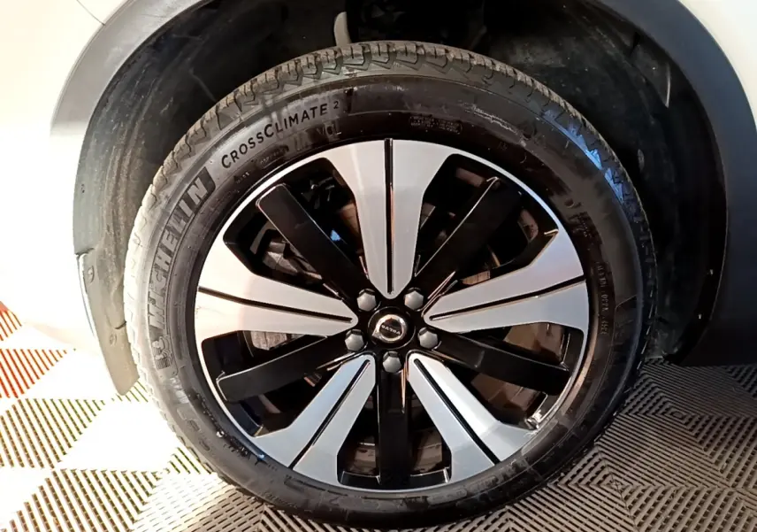 Gros plan sur la roue avant droite du Volvo XC40 Recharge T5 262 DCT7 Plus avec jante bicolore noir et argent.