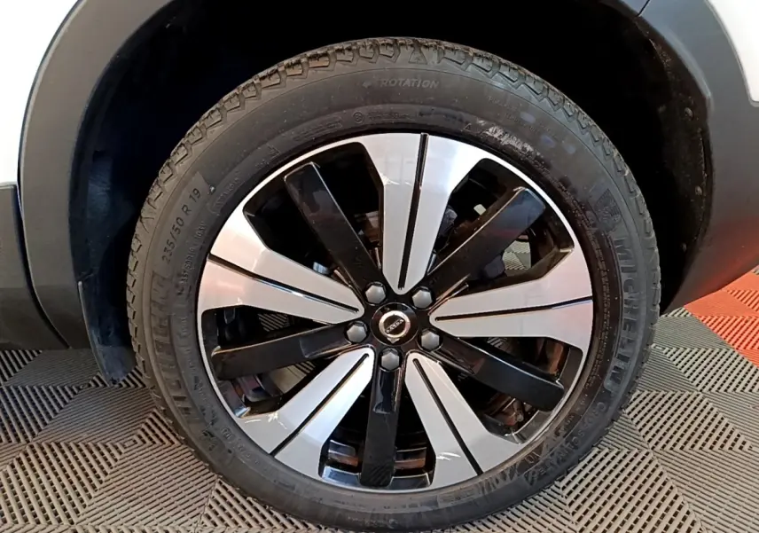 Gros plan sur la roue avant gauche du Volvo XC40 hybride rechargeable, jante alliage bicolore noir et argent.