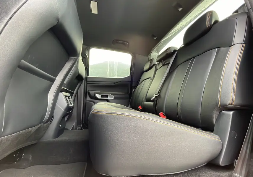 Vue intérieure arrière côté droit du Ford Ranger gris carbone, montrant les sièges en cuir noir avec surpiqûres jaunes.