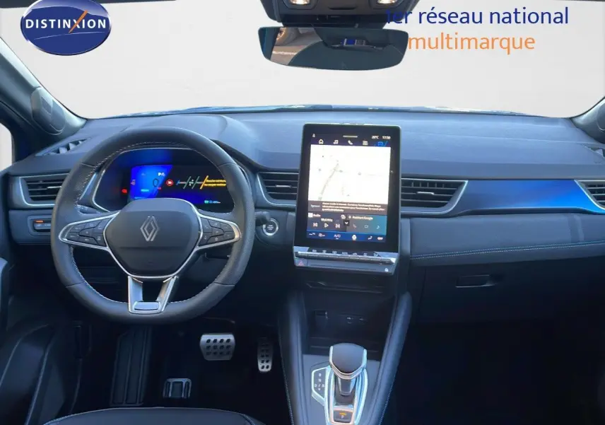 Vue intérieure avant du tableau de bord et volant noir de la Renault Symbioz 1.6 E-TECH hybride avec écran tactile central vertical.