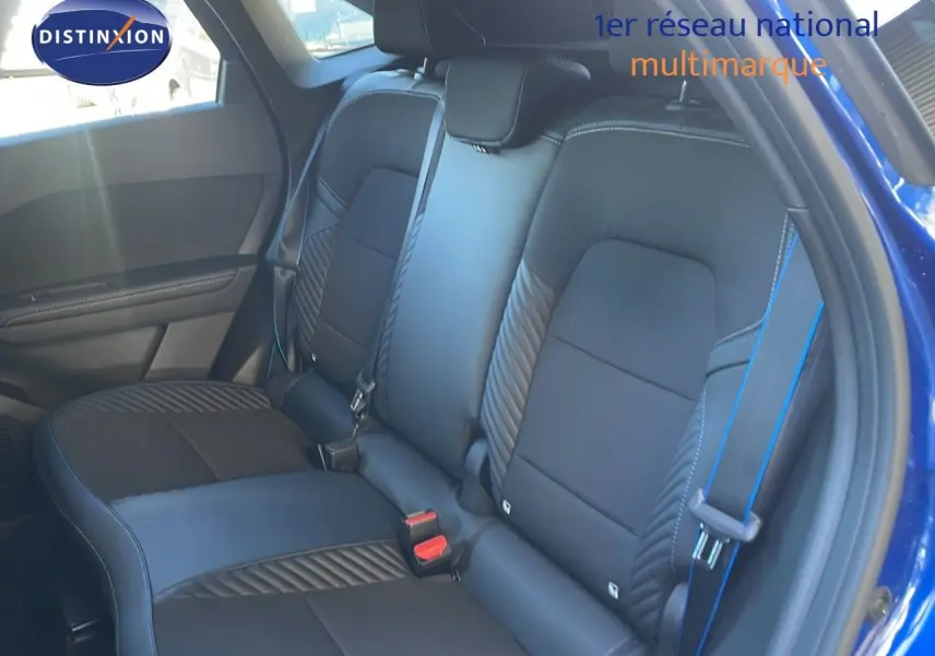 Vue intérieure montrant la banquette arrière en cuir noir avec surpiqûres bleues du Renault Symbioz bleu Iron Metal.