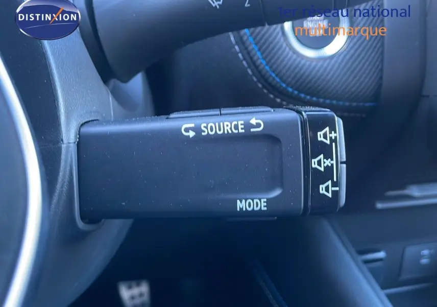 Gros plan sur la commande au volant noire avec inscriptions blanches "SOURCE" et "MODE" dans un Renault Symbioz 2025.