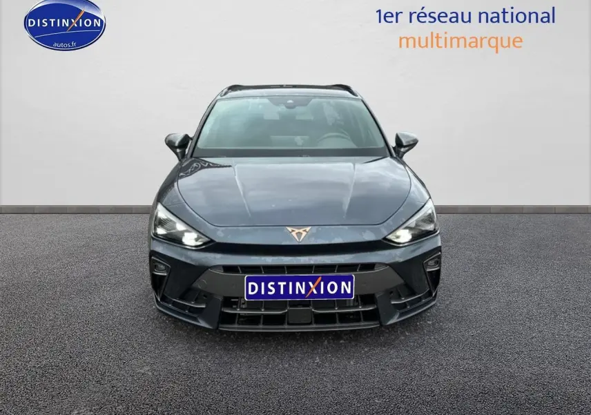 Vue frontale d'une CUPRA Leon ST 2025 gris magnétique avec phares LED allumés et logo distinctif sur calandre.