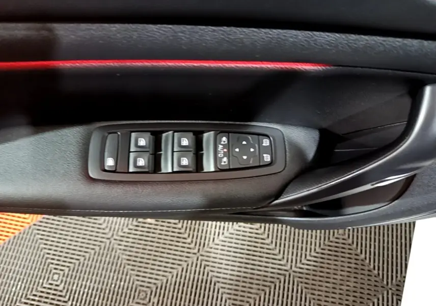Détail des commandes de lève-vitres et rétroviseurs sur la porte côté conducteur de la Renault Mégane Techno blanche 2023.