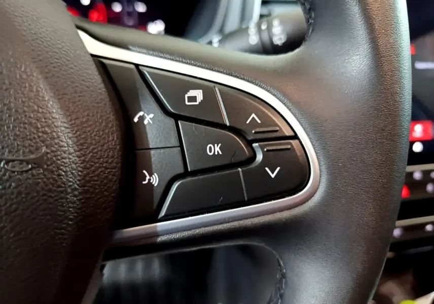 Gros plan sur les commandes multifonctions noires du volant côté gauche de la Renault Mégane Techno TCe 140 EDC 2023.