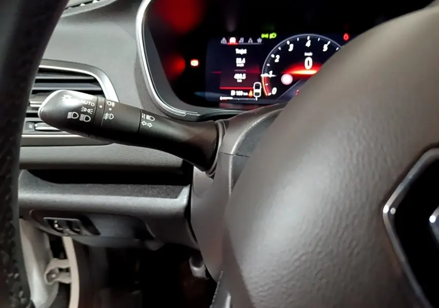Vue rapprochée du tableau de bord et du volant de la Renault Mégane Techno TCe 140 blanc, avec affichage numérique rouge.