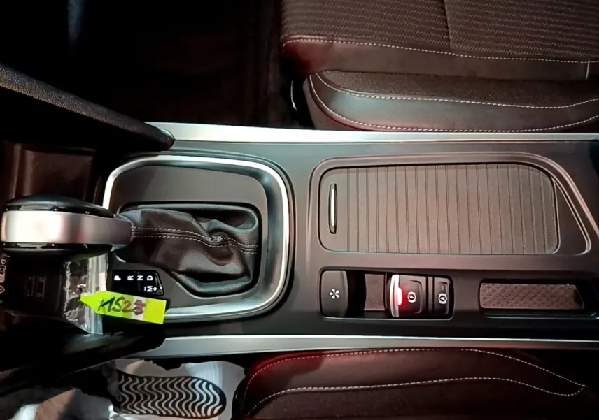 Vue plongeante sur la console centrale noire de la Renault Mégane Techno TCe 140 EDC 2023 avec levier de boîte auto et sièges en tissu.