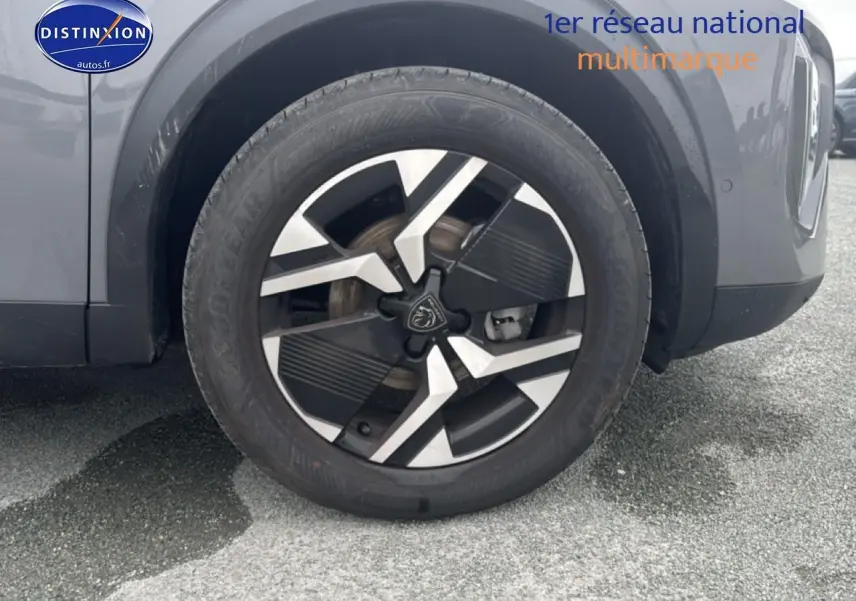Gros plan sur la roue avant gauche et la jante alu bicolore du Peugeot 2008 gris sellenium.