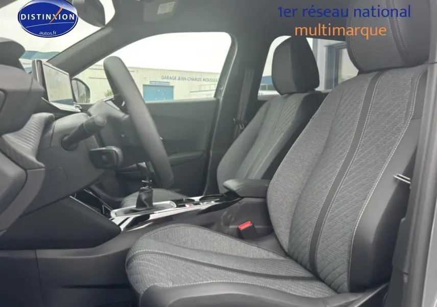 Vue intérieure côté gauche du Peugeot 2008 1.2 100 allure 2025, sièges tissu gris casual lomsa embossé avec volant multifonction.