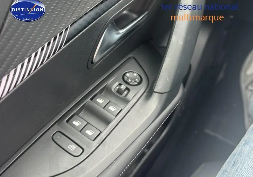 Gros plan sur les commandes des vitres électriques côté gauche d’une Peugeot 2008 gris sélénite, finition Allure.